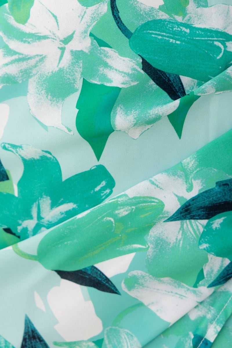 Close-up of floral print in vibrant green tones on a vacation-ready maxi dress fabric.