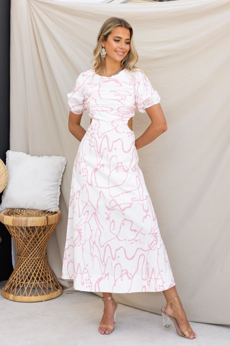 Jaida Maxi Dress: Elegant cotton dress with puffed sleeves, cut-out waist, and pink abstract print, styled for summer.