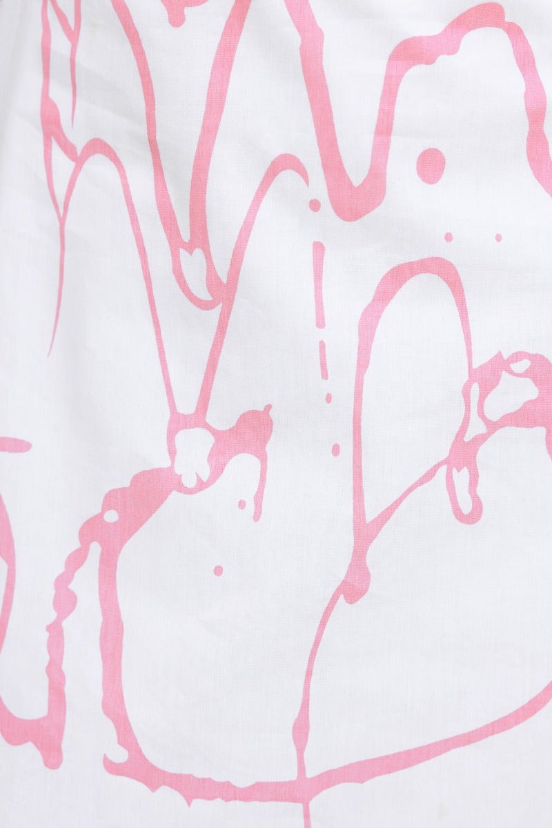 Close-up of pink abstract paint pattern on soft cotton fabric, showcasing a stylish design for the Jaida Maxi Dress.