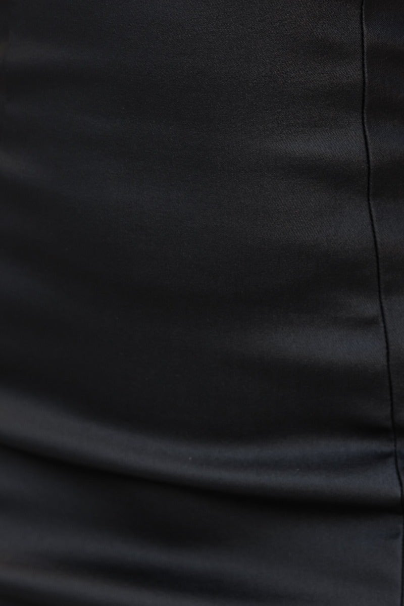 Close-up of black faux leather material, showcasing smooth texture of Talon Dress with adjustable straps.