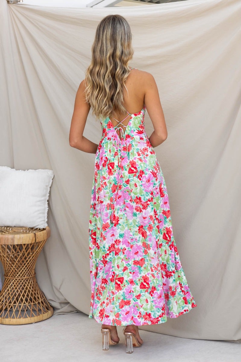 Back view of the Swish Maxi Dress featuring a floral print, adjustable tie straps, and a crossover design.