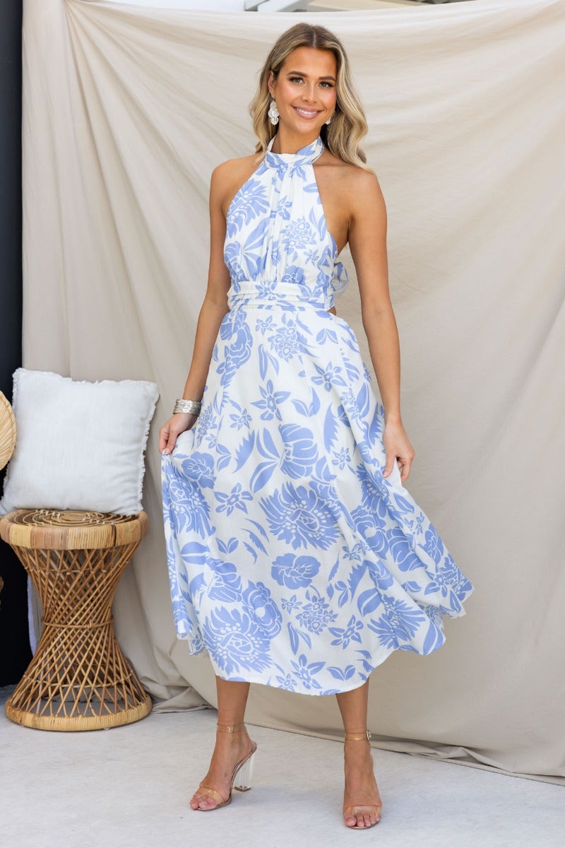 Model in a floral Corio Midi Dress with a tie halter neckline, showcasing a light blue and white design.