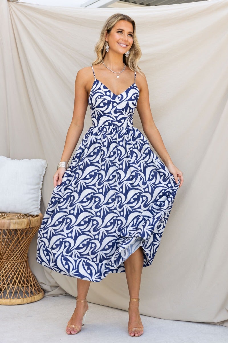 Navy cotton blend Vallere maxi dress with adjustable straps, V-neckline, pockets, and flowing skirt.