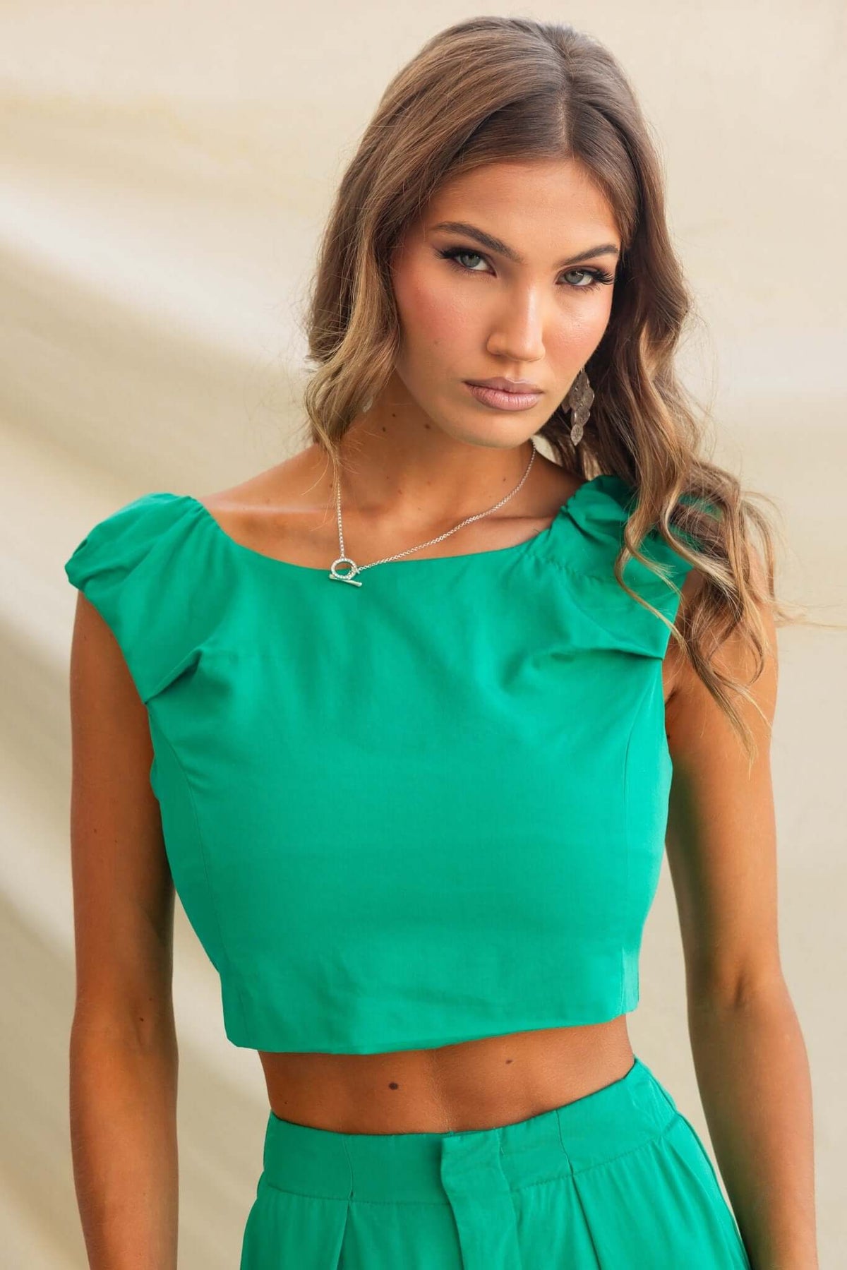 Erik Top in vibrant green with boat neckline and elastic straps, model wears size 8/S, stylish cropped fit.