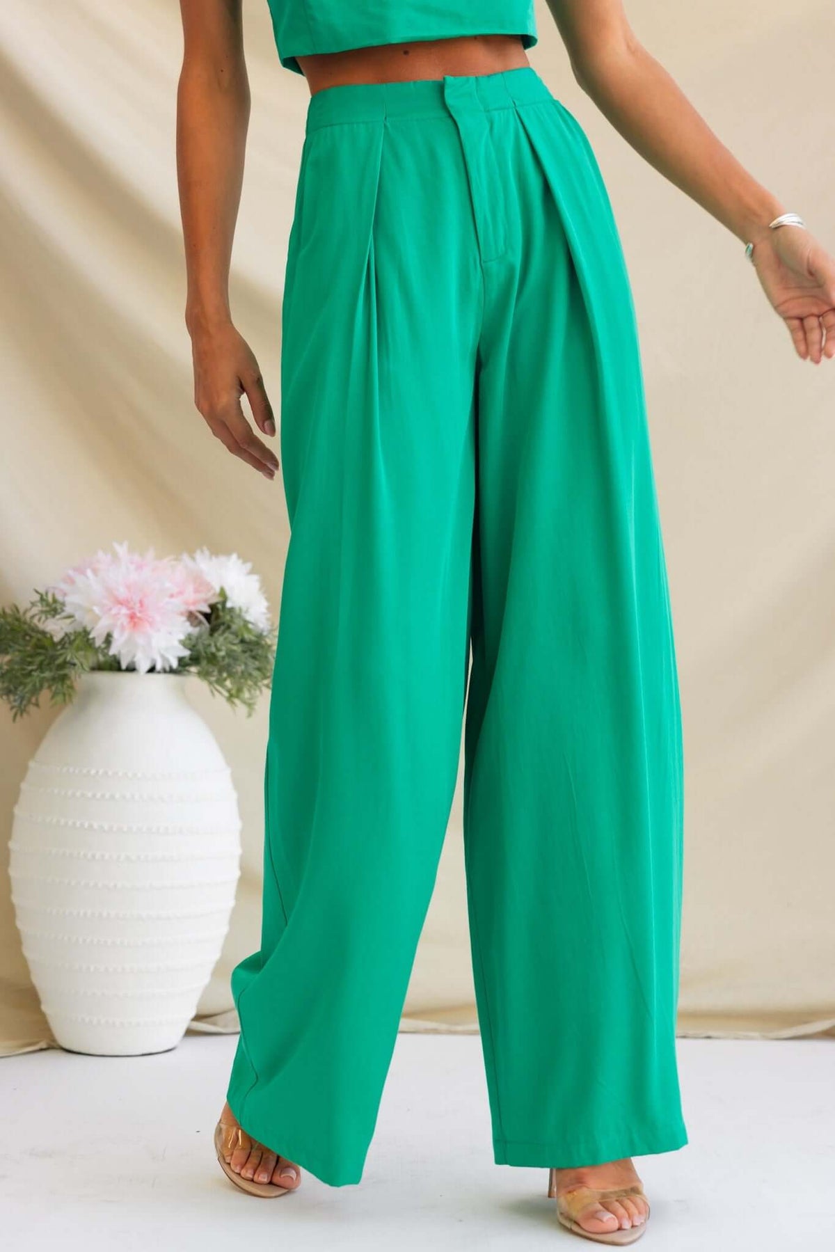 Stylish Erik Pants in vibrant green, featuring a mid-high waist, pleats, and wide-leg design, showcased by a model.