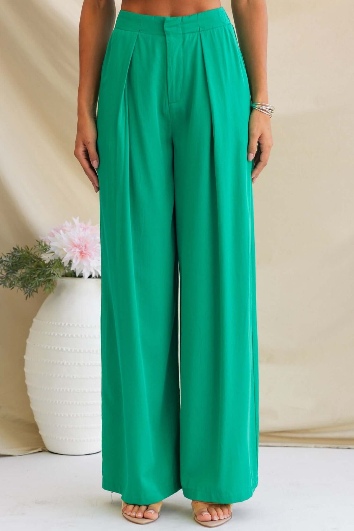 Green wide-leg Erik Pants with a mid-high waist fit, featuring faux and hip pockets, styled for relaxed elegance.