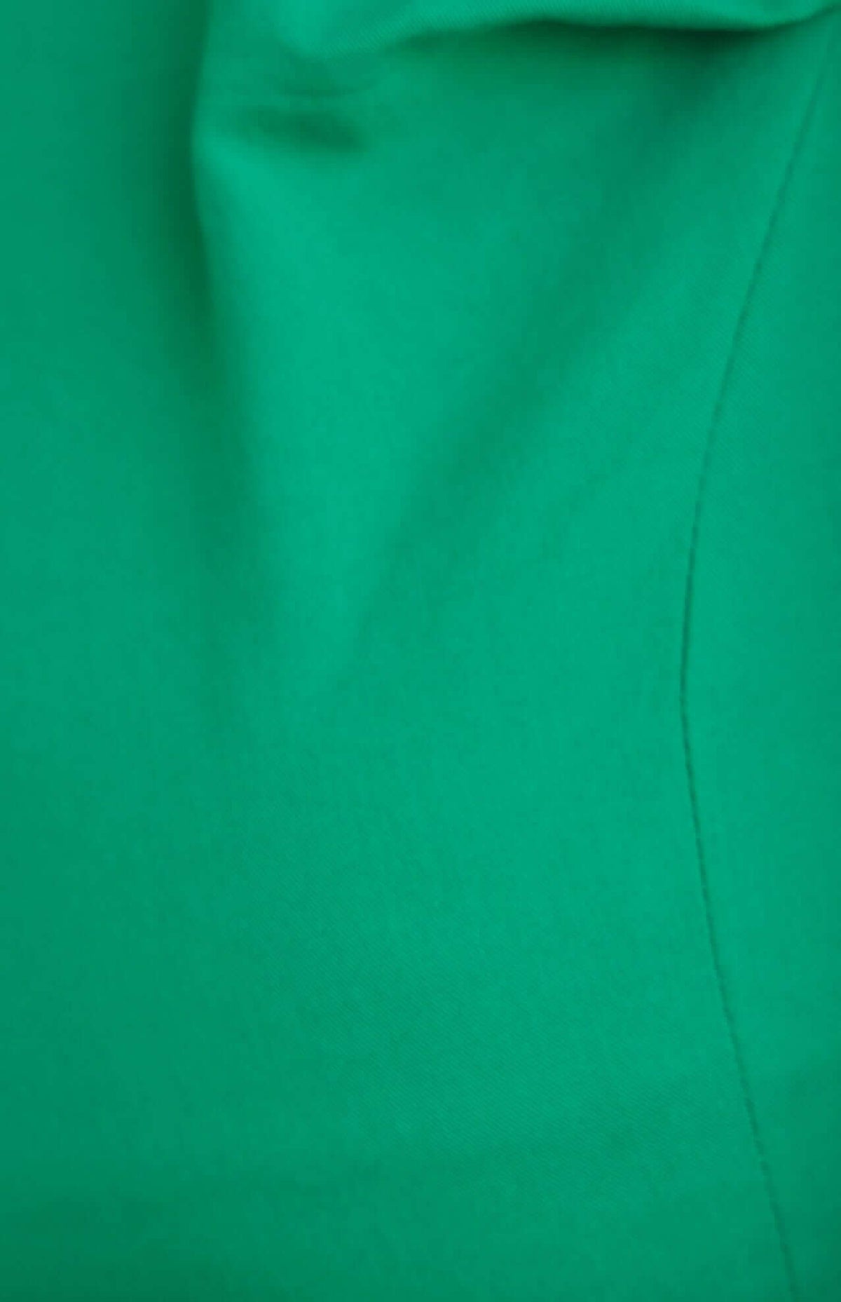 Close-up of vibrant green fabric showcasing texture and seam detail of Erik Pants.