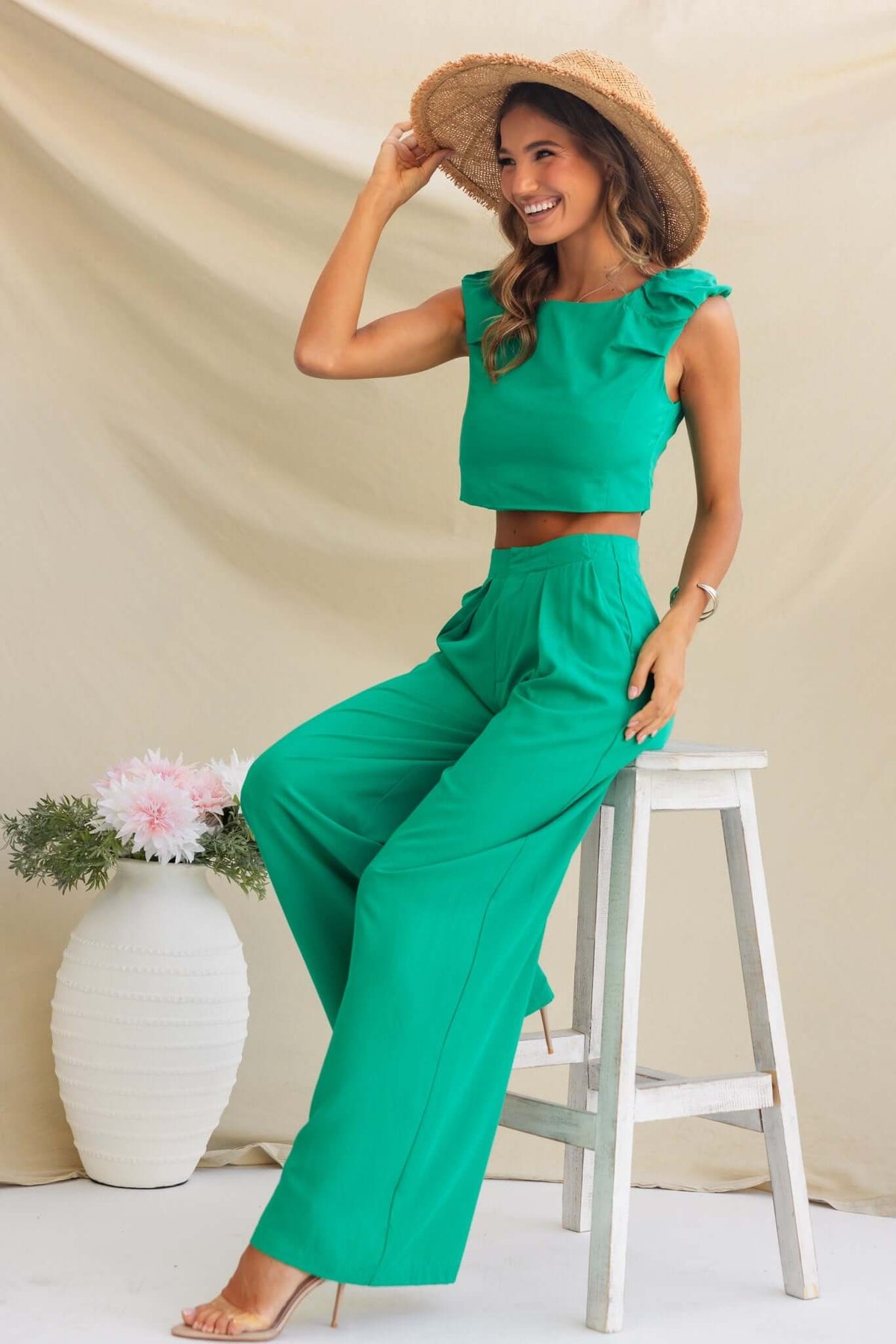 Model wearing Erik Pants, a mid-high waist green outfit, styled with a matching crop top and sunhat.