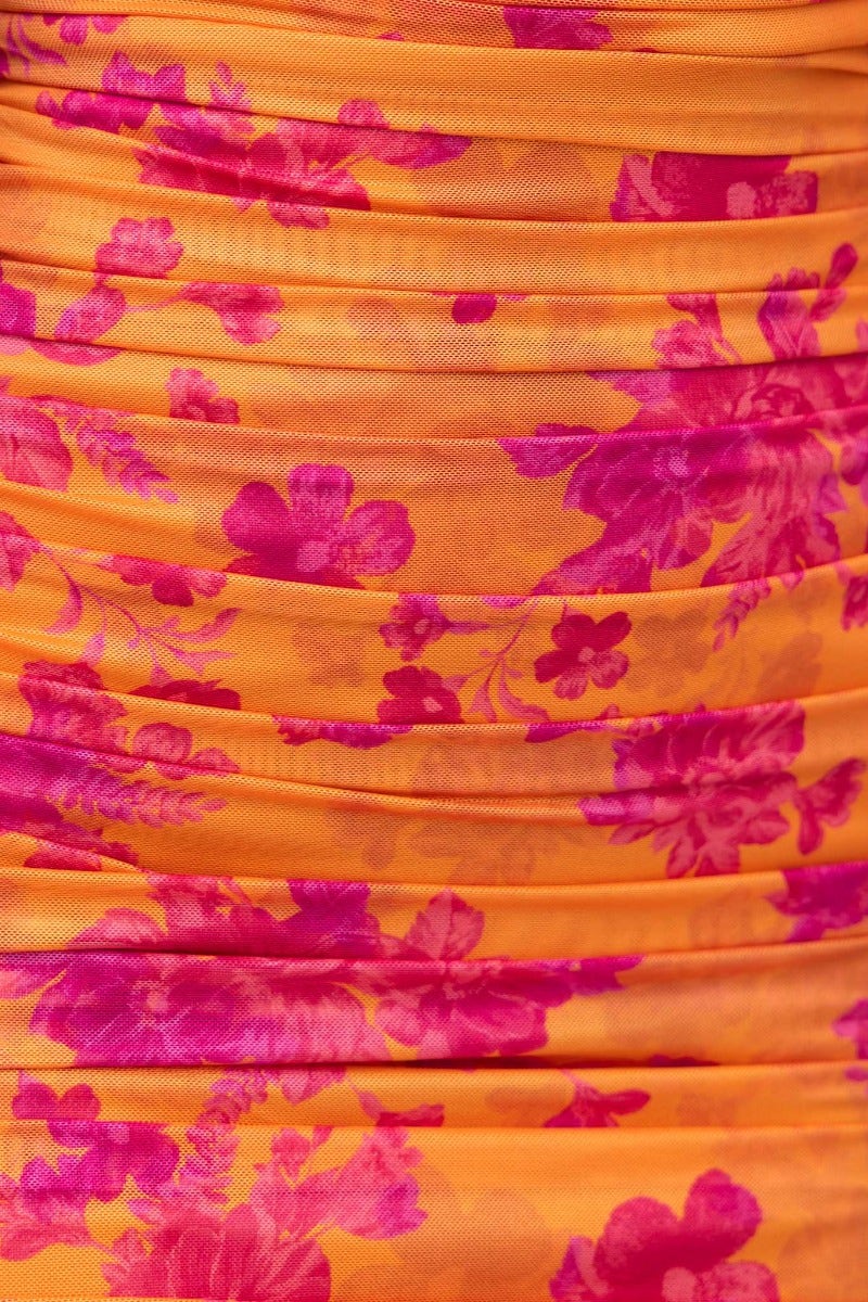 Close-up of floral print in vibrant orange and pink on Dayania Midi Dress fabric with subtle ruching.
