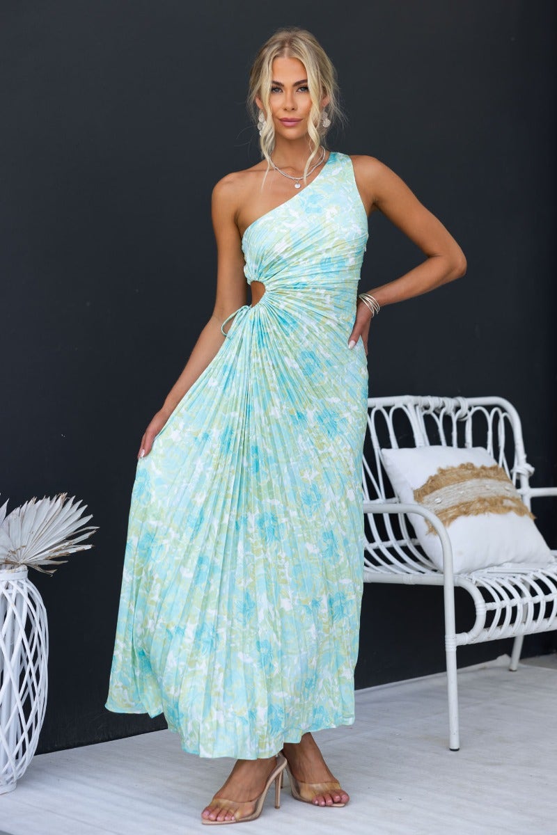 Model wearing blue floral print Ottile Maxi Dress with one-shoulder neckline and cut-out at waist.