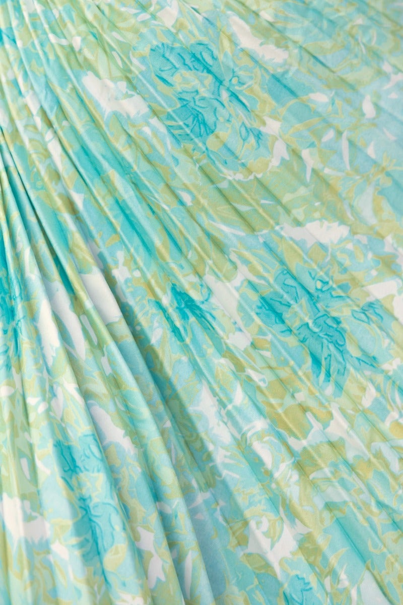 Close-up of the floral print fabric in a teal and green color scheme featuring accordion pleats.