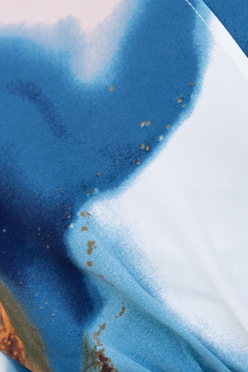 Close-up of the Qastella Dress fabric featuring blue and soft color blends with a smooth texture.