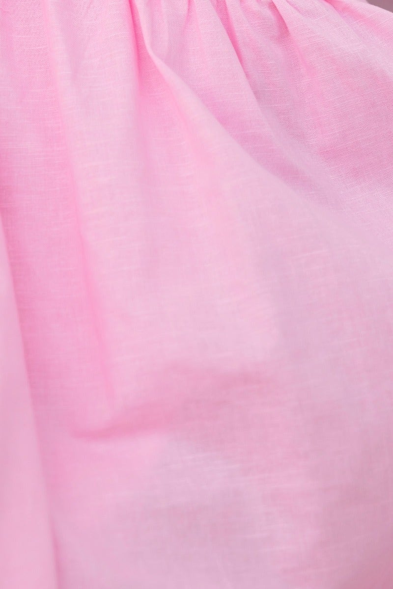 Close-up of soft pink fabric, showcasing the linen look of the Dancing Queen Maxi Dress's strapless design.