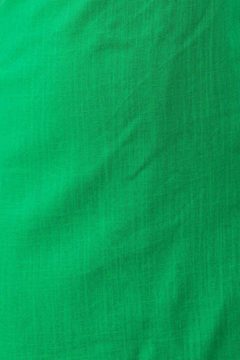 Close-up of vibrant green linen fabric, showcasing its texture and subtle weave pattern.