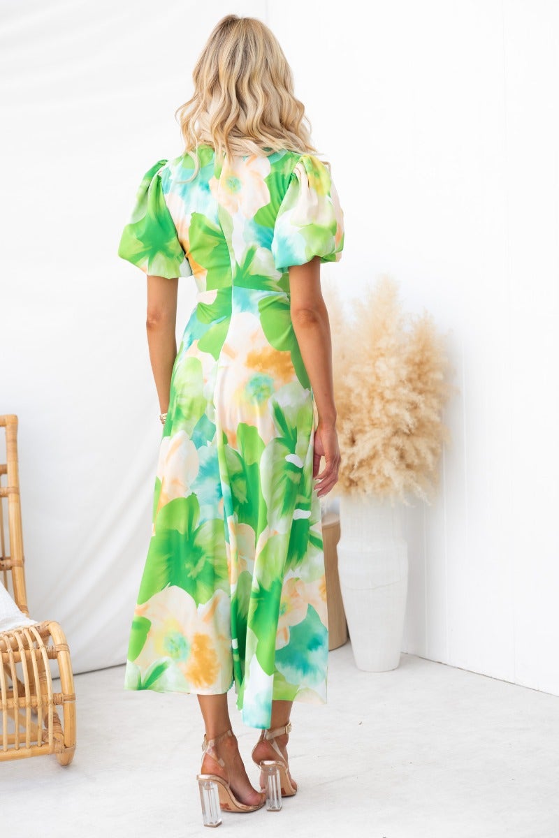 Back view of Qeilor Midi Dress featuring floral print, V-neckline, and puff sleeves in a vibrant green pattern.