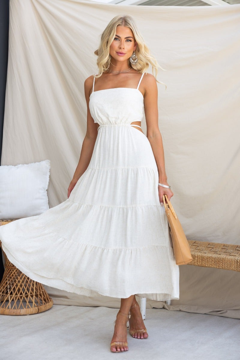 Brookman Midi Dress in white with adjustable straps, cut-out waist, and flowing skirt, perfect for summer events.