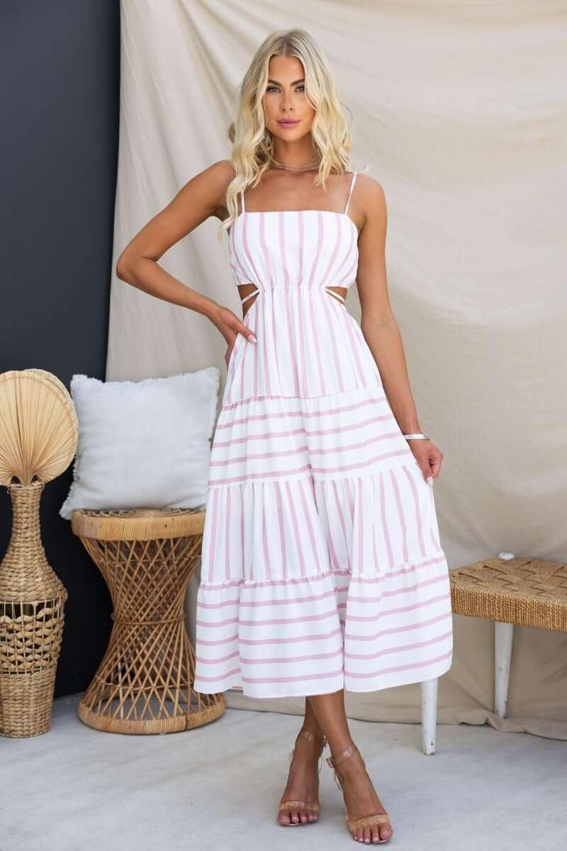 Model wearing Brookman Midi Dress featuring adjustable straps, cut-out waist, and striped linen design.