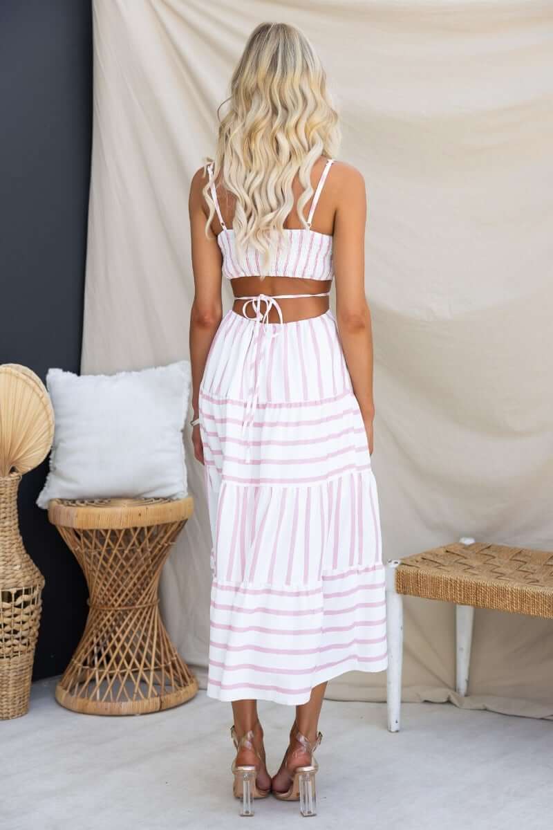Back view of Brookman Midi Dress featuring adjustable straps and a tied waist, styled with natural decor.