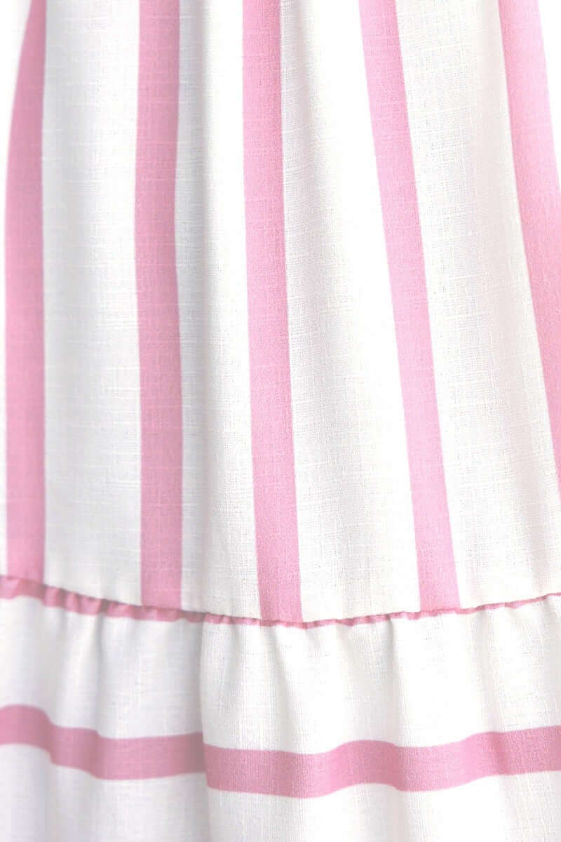 Close-up of the Brookman Midi Dress featuring a white fabric with pink striped pattern and ruffled hem.