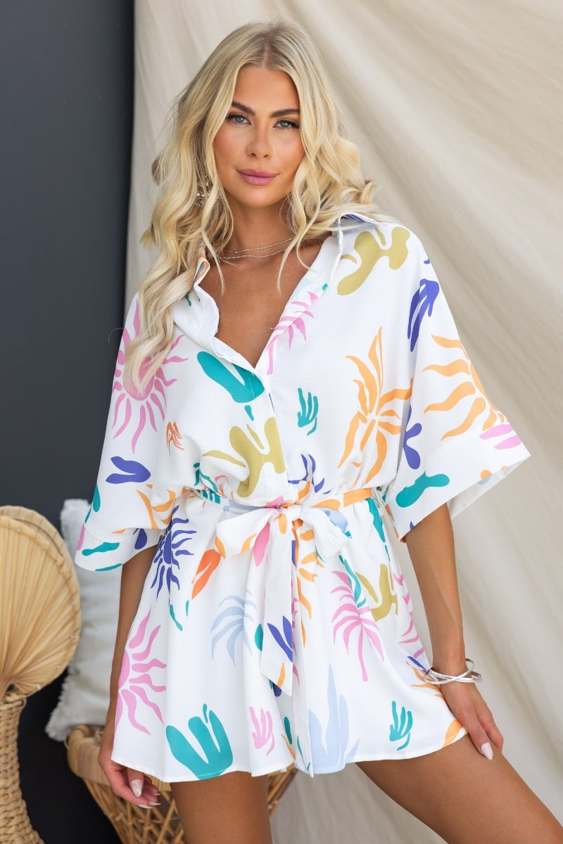 Leonie Playsuit featuring a vibrant abstract print, collar, button-up front, and removable fabric tie, styled for an oversized fit.