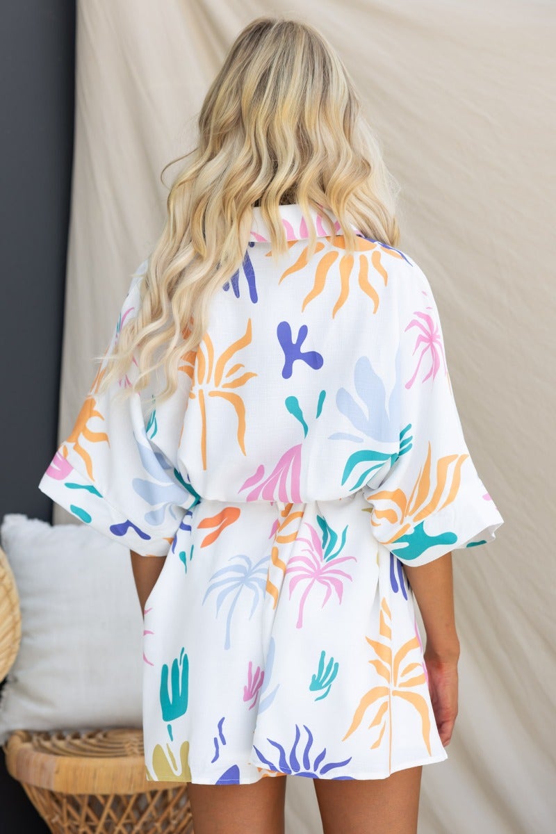 Model wearing colorful abstract print Leonie Playsuit, showcasing the back design and removable fabric tie.