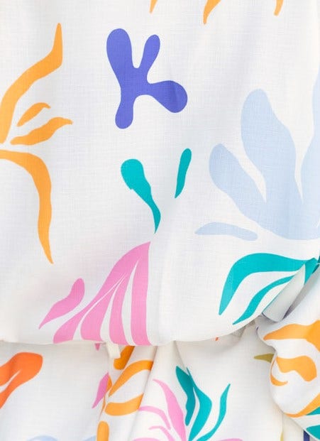 Colorful abstract floral print close-up of Leonie Playsuit fabric, showcasing vibrant patterns and linen texture.