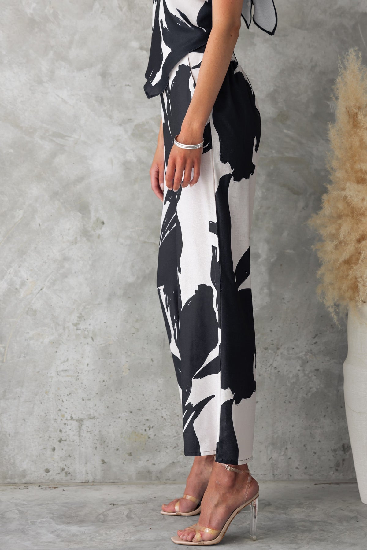 Side view of Yanna Pants featuring a black and white print, mid-high waist, and an elastic back waistband.