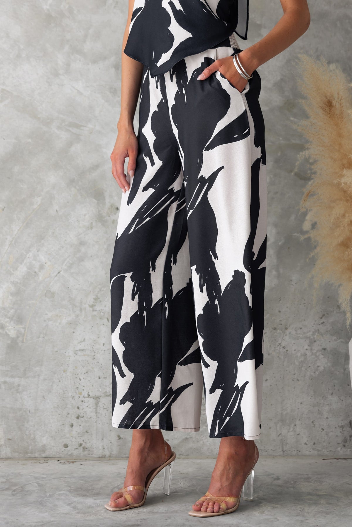 Black and white printed Yanna Pants featuring mid-high waist, elastic back, and pockets, styled effortlessly.