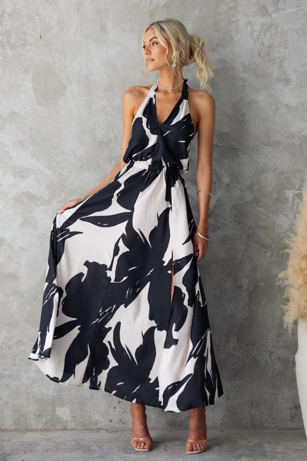 Black and white floral Casilda maxi dress with adjustable tie neckline and front split, showcased on a model.