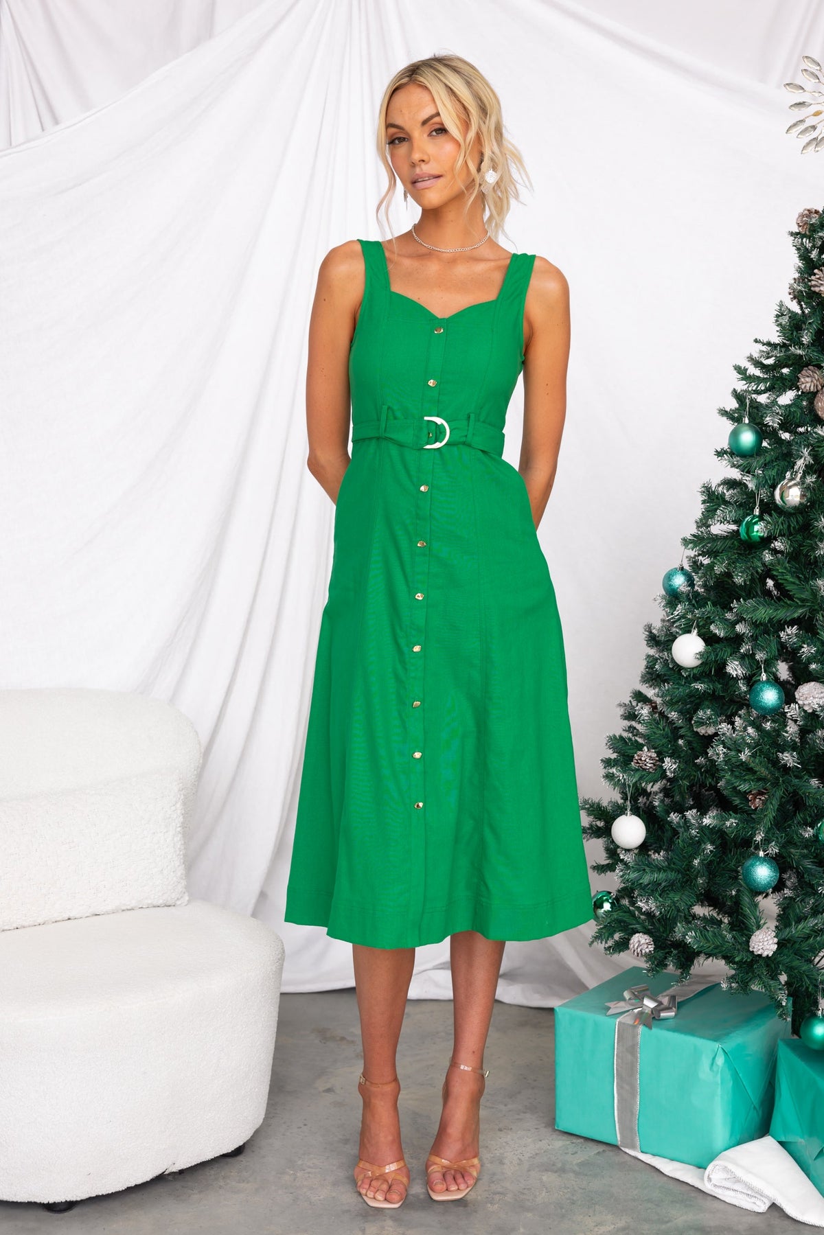 Corella Midi Dress in green with button-up front, removable belt, and pockets, styled for a festive look.