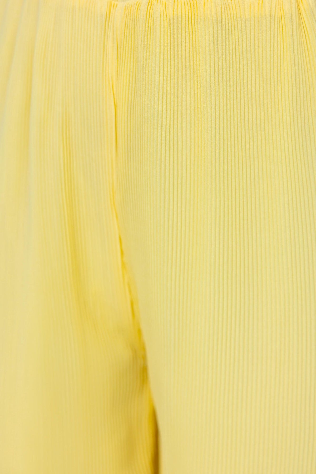 Close-up of pleated yellow fabric showcasing the texture of the material.