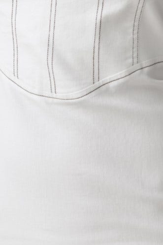 Close-up of soft white fabric featuring detailed stitching, showcasing texture and design elements.
