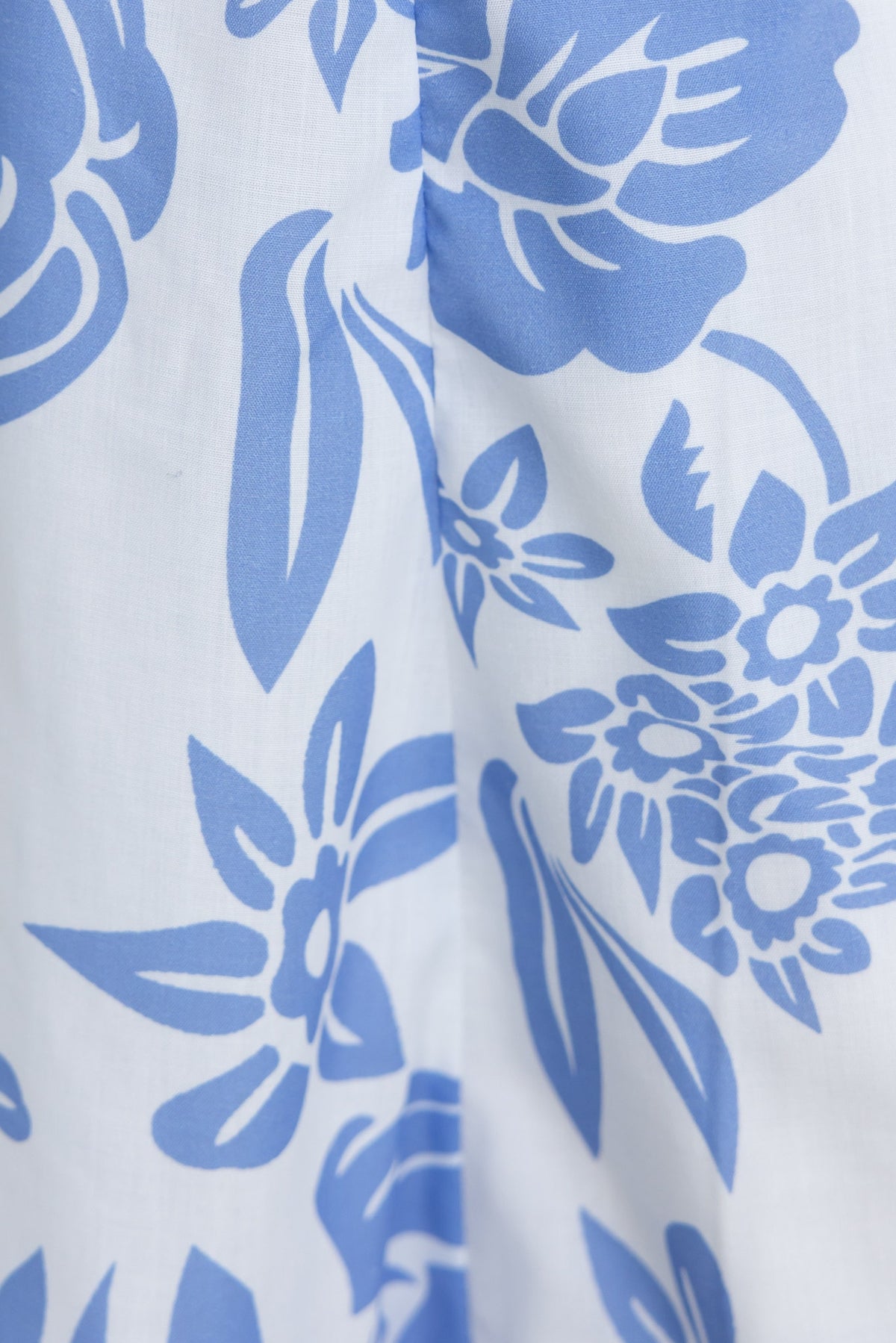 Close-up of Corio Midi Dress fabric featuring blue floral patterns on a white background.
