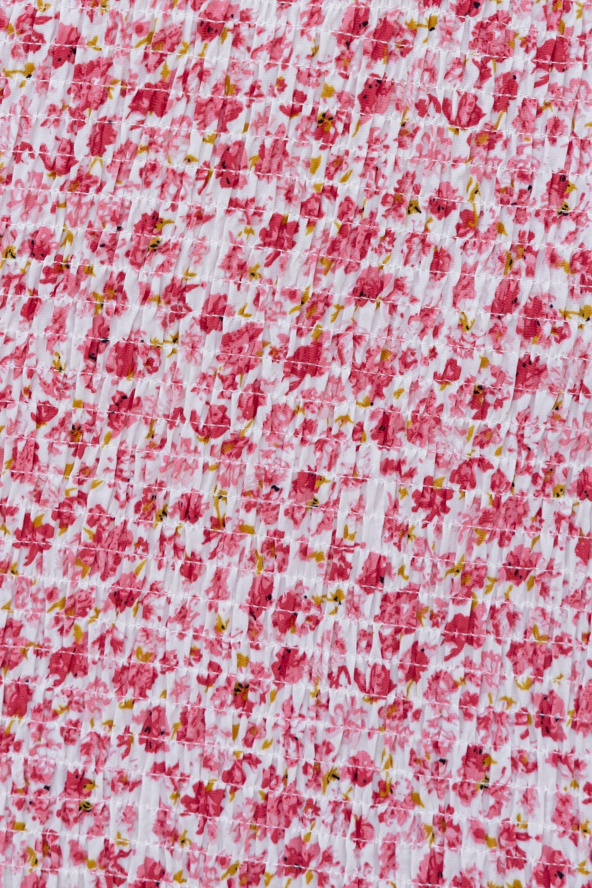 Close-up of floral print fabric in pink and white, showcasing textured shirred design for the Akima Midi Dress.