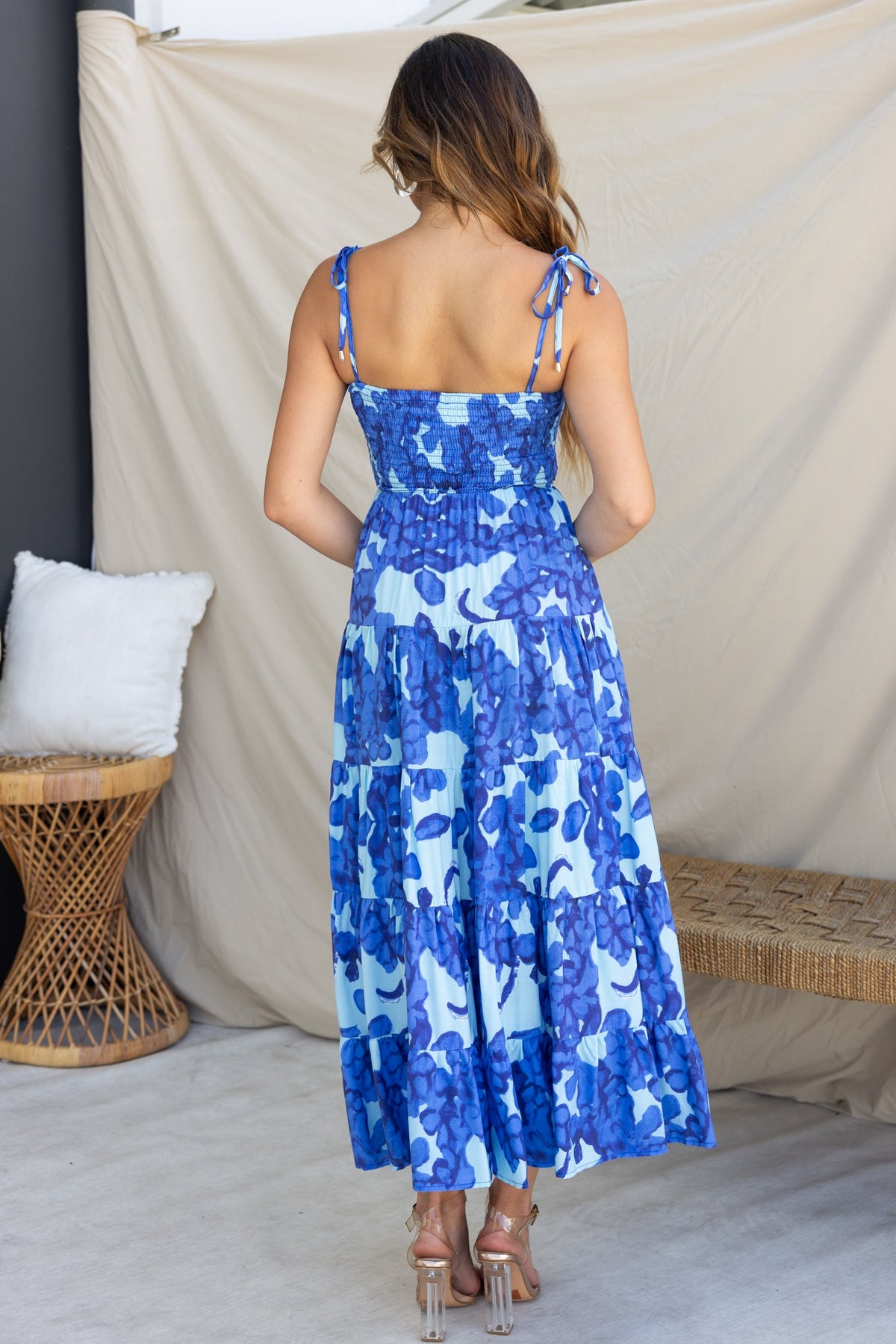 Back view of Inessa Midi Dress featuring adjustable tie straps and vibrant blue floral pattern.