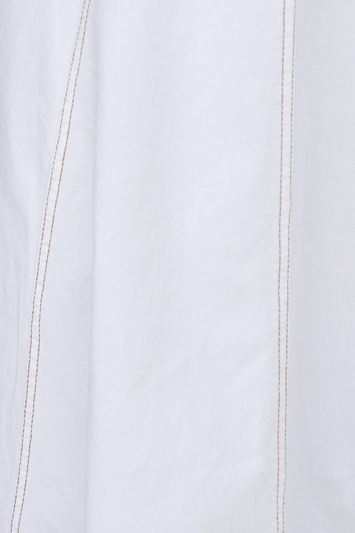 Close-up of white fabric with brown stitching details, showcasing texture and design features of the Pallara Denim Midi Dress.
