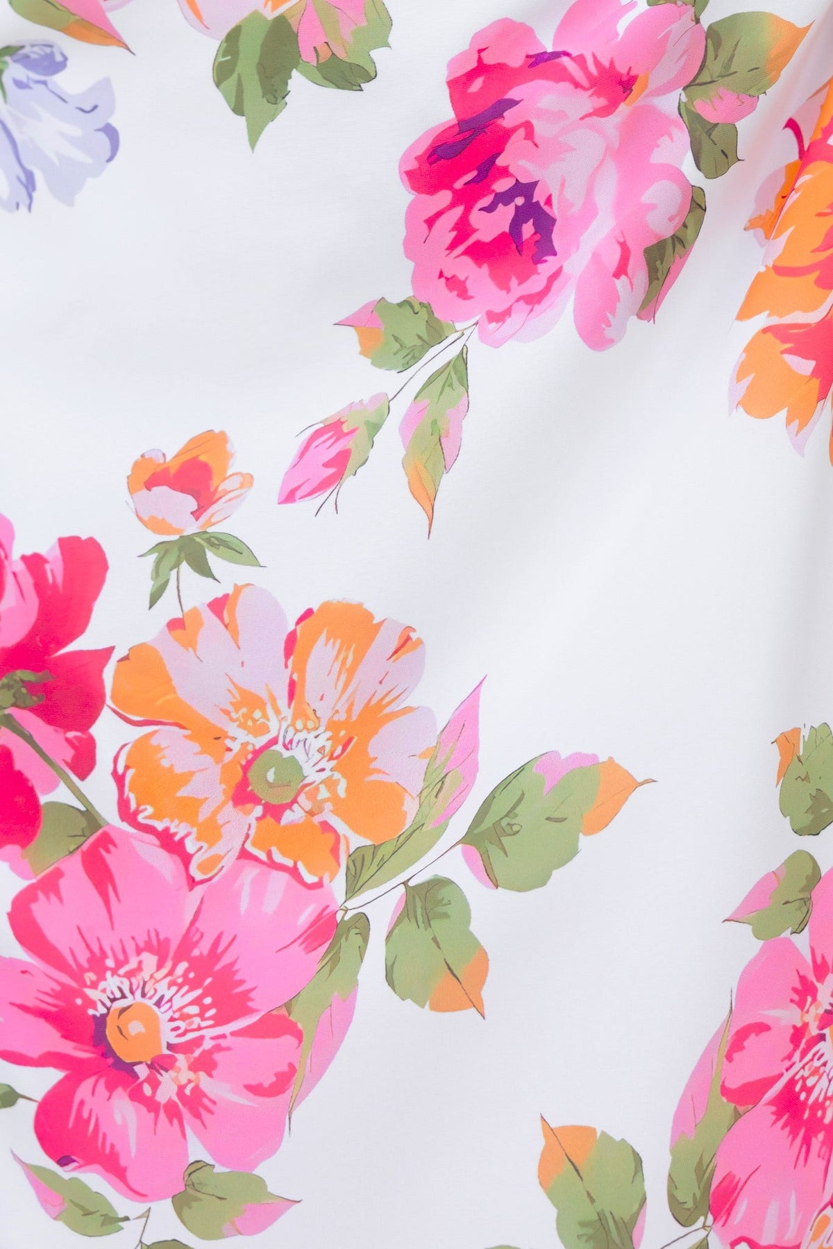 Close-up of vibrant floral print featuring pink, orange, and green flowers on a white background.