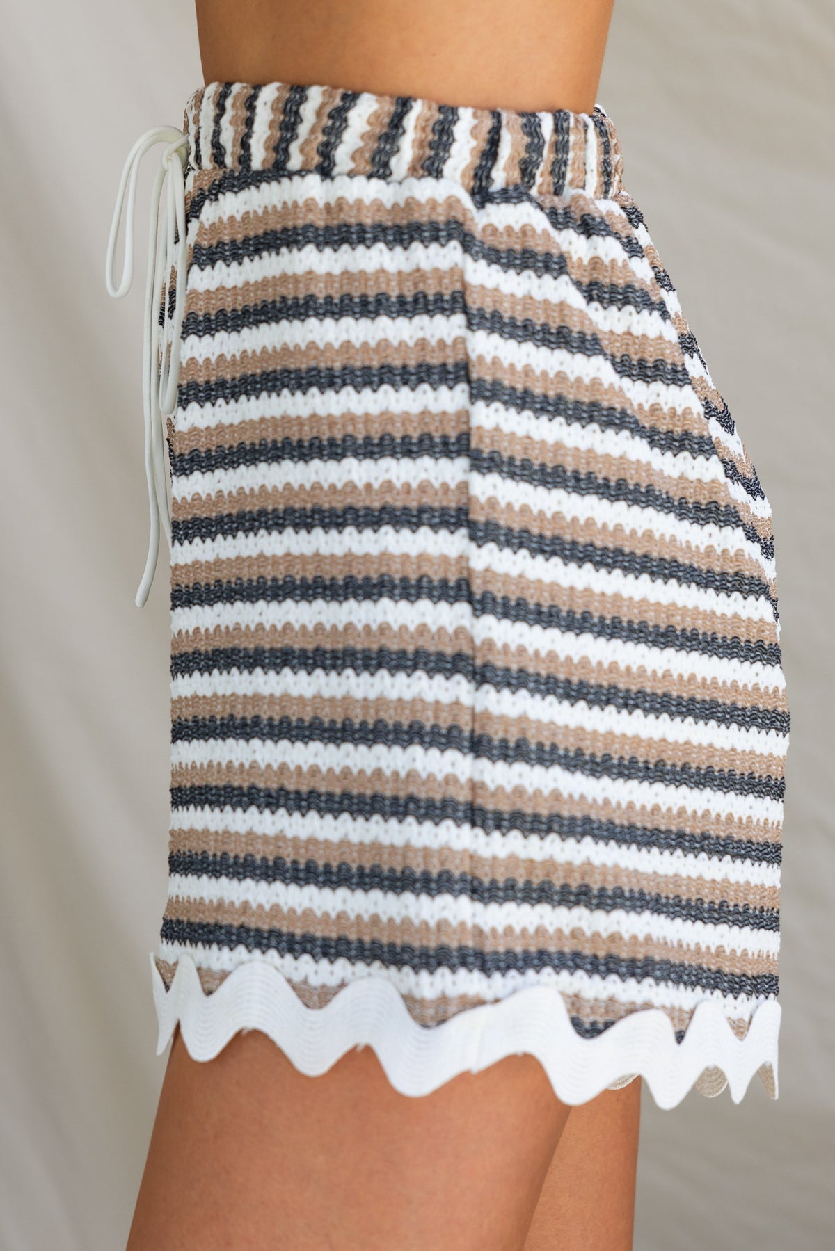 Salata shorts featuring mid-high waist, elastic waistband, and striped textured fabric with tie detail.