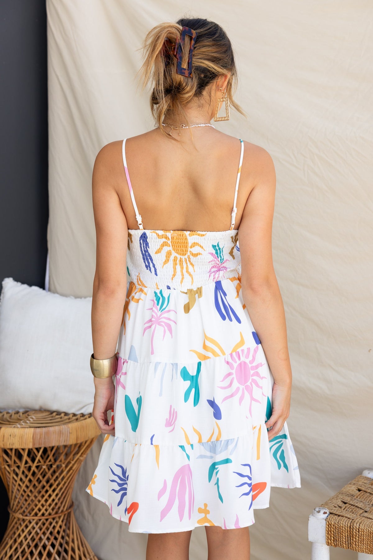 Back view of Romee Dress featuring abstract print, adjustable straps, and layered ruffles in vibrant colors.