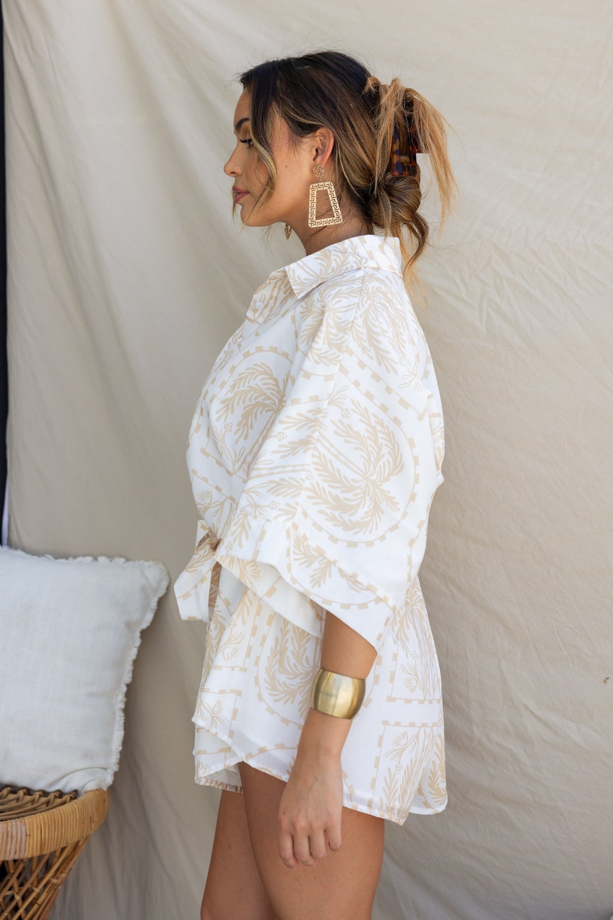 Model wearing Alli Playsuit with collar, button-up style, and removable tie, featuring a light cotton feel and oversized fit.