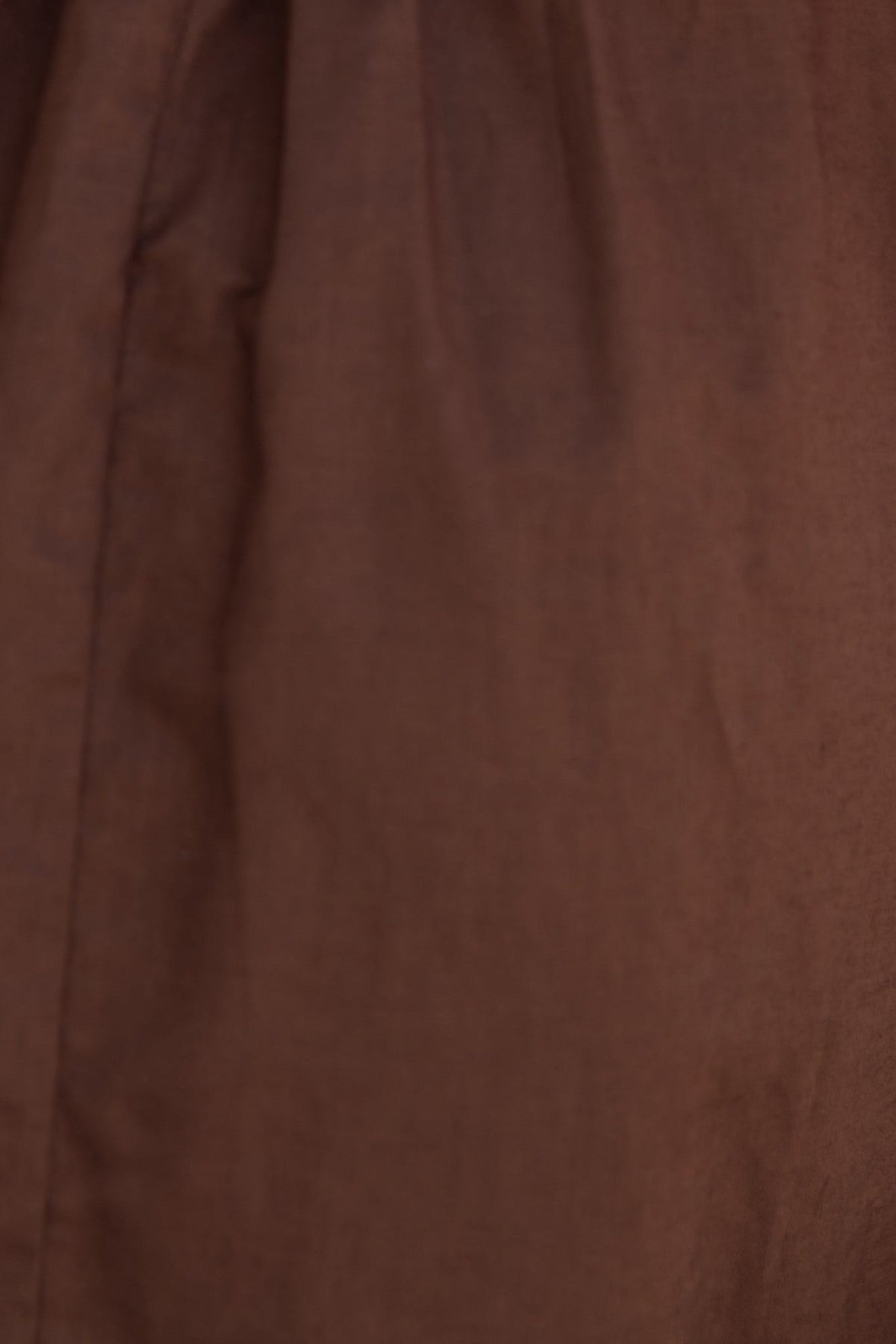 Close-up of the Osment Dress fabric in rich brown linen texture, showcasing its soft, non-stretch material.