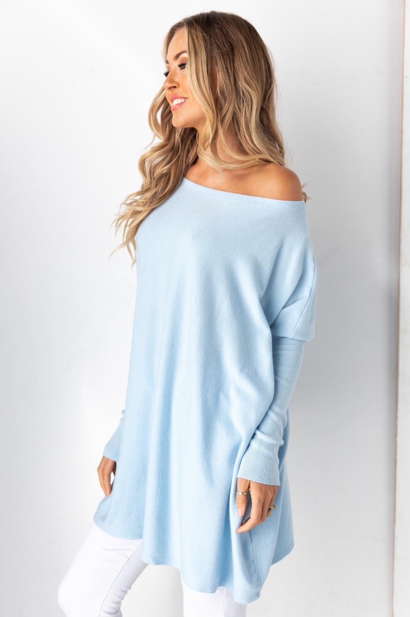 Woman wearing a cozy oversized Bonnie Knit blue top dress with full-length sleeves and a relaxed fit.