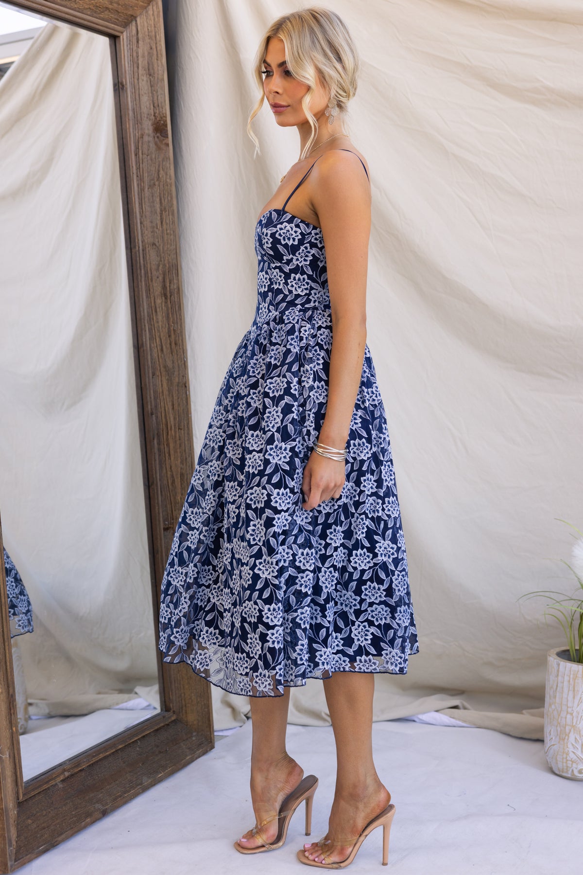 Model wearing the Ambient Midi Dress with adjustable straps and lace material, showcased against a mirror backdrop.