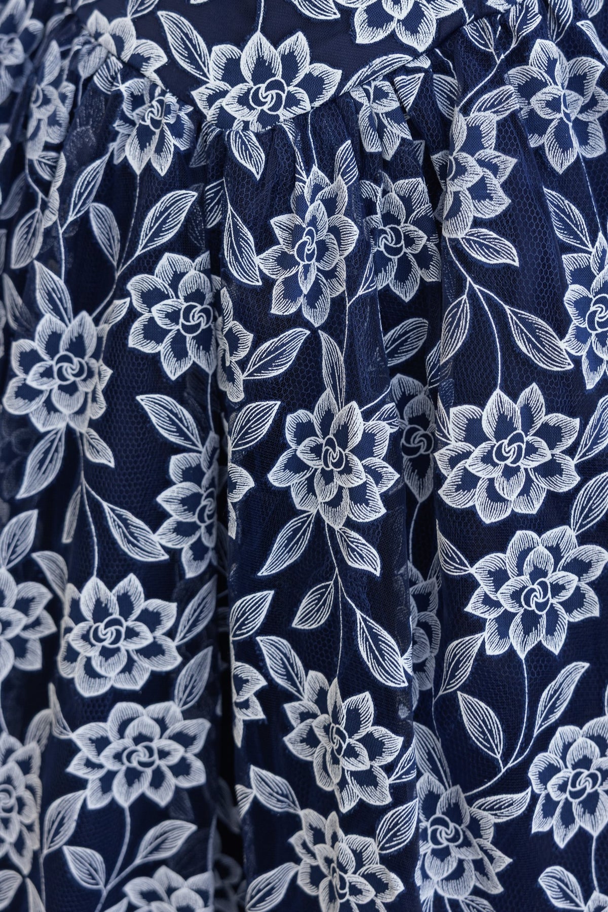 Close-up of navy floral lace fabric on the Ambient Midi Dress featuring intricate floral patterns.