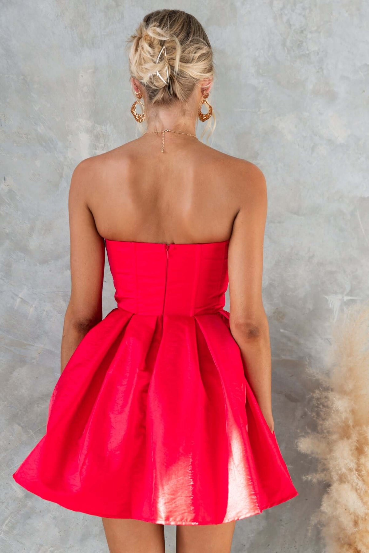 Back view of strapless Aminah dress in bright red, featuring boning, tulle underlay, and invisible zip.