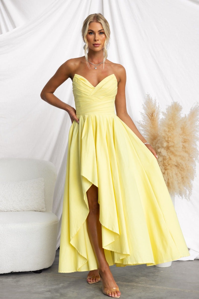 Model wearing a strapless yellow maxi dress with asymmetric hem, showcasing elegant styling and comfortable fit.