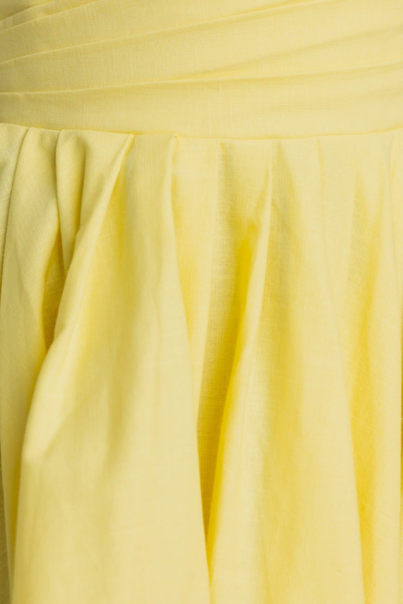 Close-up of the yellow fabric detailing of the Kiss And Tell Maxi Dress, showcasing its soft texture and elegant pleats.