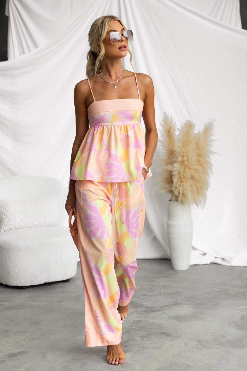 Model wearing Ibiza Pants with abstract print, mid-high waist, elastic waistband, and summer style in a bright setting.