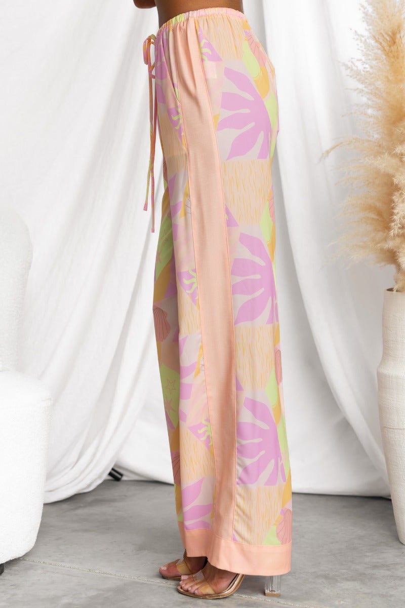 Ibiza Pants featuring abstract print, mid-high waist, and elastic waistband with drawstring for a relaxed fit.