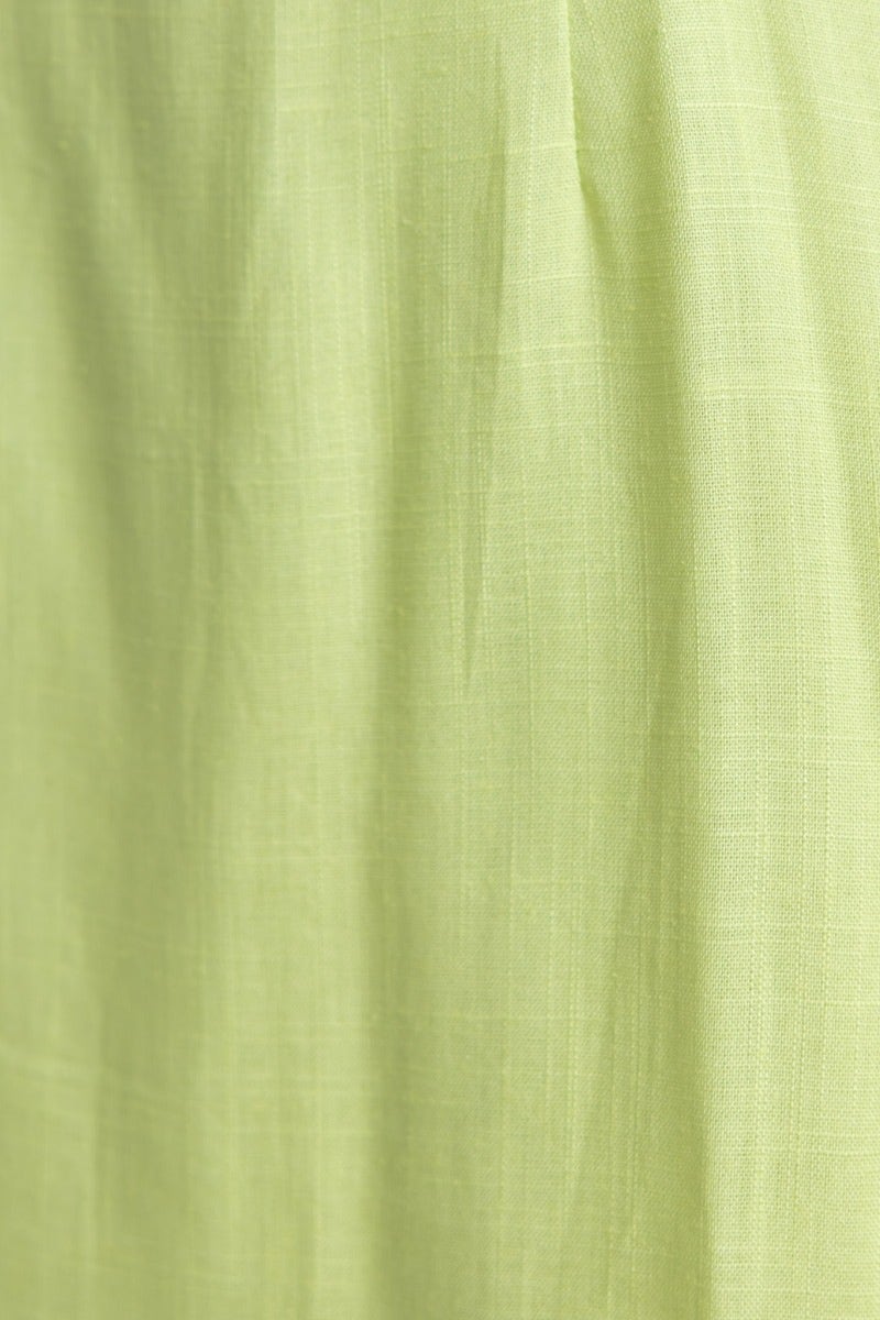 Close-up of light green linen fabric showcasing soft texture, ideal for stylish summer mini dresses.